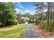 Secluded home with a long driveway surrounded by lush landscaping, mature trees, and a beautifully maintained lawn at 1064 Highway 20 E, Mcdonough, GA 30252