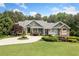 Stunning home with circular driveway, lush lawn, mature trees, and manicured landscaping at 1064 Highway 20 E, Mcdonough, GA 30252