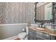 Elegant half bathroom featuring black and white patterned wallpaper, dark gray vanity, and ornate mirror at 1064 Highway 20 E, Mcdonough, GA 30252