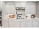 Close-up of kitchen featuring white cabinets, white backsplash, and modern appliances at 1064 Highway 20 E, Mcdonough, GA 30252