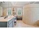 Main bathroom with dual sinks, mirrors, walk in shower, and tile floors at 1064 Highway 20 E, Mcdonough, GA 30252