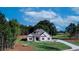 Idyllic white farmhouse with dark shutters, a gray roof, and a well-kept lawn under a bright sky at 140 Paislee Park (Lot #5 Paislee Park) Dr, Fayetteville, GA 30215