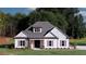 Charming white farmhouse with a gray roof and shutters, complemented by a lush green lawn at 140 Paislee Park (Lot #5 Paislee Park) Dr, Fayetteville, GA 30215