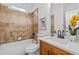 Cozy bathroom with shower-tub combo, wood vanity, and stone tile at 1481 Wild Rye Ln, Grayson, GA 30017