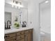 Bathroom featuring dual sinks, quartz counters, wood cabinets, and a large mirror at 1481 Wild Rye Ln, Grayson, GA 30017