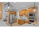 Well-lit eat-in kitchen with stainless steel appliances and maple cabinets at 1481 Wild Rye Ln, Grayson, GA 30017