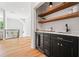 Stylish bar area with dark cabinetry, open shelving, a wine cooler and hardwood floors at 3267 Sewell Mill Rd, Marietta, GA 30062