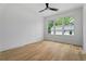Bright bedroom with hardwood floors, ceiling fan, and large window overlooking lush greenery at 3267 Sewell Mill Rd, Marietta, GA 30062