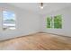 Sun-filled bedroom with hardwood floors, a ceiling fan, and two large windows with green outdoor views at 3267 Sewell Mill Rd, Marietta, GA 30062