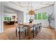 Bright dining room boasts unique ceiling detail, modern lighting, and views to the manicured greenery outside at 3267 Sewell Mill Rd, Marietta, GA 30062