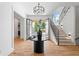 Grand foyer featuring hardwood floors, elegant lighting, and a staircase with a black metal banister at 3267 Sewell Mill Rd, Marietta, GA 30062
