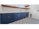 Modern laundry room with blue cabinets, light countertops, patterned tile floors, and stainless steel sink at 3267 Sewell Mill Rd, Marietta, GA 30062