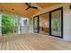Covered porch with ceiling fan, wood flooring and white brick, seamlessly connecting indoor and outdoor spaces at 3267 Sewell Mill Rd, Marietta, GA 30062