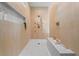 Modern walk-in shower featuring wood-look tile, a built-in bench, rainfall shower head and gold fixtures at 3267 Sewell Mill Rd, Marietta, GA 30062