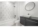 Stylish bathroom with a modern vanity, large mirror, and a tub with geometric tile surround at 34 Candler Ne Rd, Atlanta, GA 30317