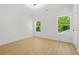 Bright bedroom featuring light hardwood floors and windows with green, leafy views at 34 Candler Ne Rd, Atlanta, GA 30317