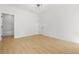 Bright bedroom featuring light hardwood floors, a modern light fixture, and an ensuite bathroom at 34 Candler Ne Rd, Atlanta, GA 30317