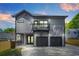 New construction gray home featuring a balcony, a two-car garage, and modern outdoor lighting at 34 Candler Ne Rd, Atlanta, GA 30317