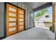 Inviting front porch featuring a modern wood-frame glass door and gray painted wood paneled siding at 34 Candler Ne Rd, Atlanta, GA 30317