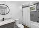 Well-lit bathroom featuring a modern vanity, tiled shower, and stylish round mirror at 1334 Milton Se Pl, Atlanta, GA 30316