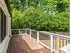 Wooden deck with white and black railings surrounded by lush green trees creating a private outdoor space at 1334 Milton Se Pl, Atlanta, GA 30316