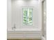Bright bathroom features a window with views, a soaking tub, and elegant fixtures at 5205 Riverview Nw Rd, Atlanta, GA 30327