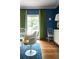 A Stylish dining area with blue walls, natural light, hardwood flooring, and elegant decor with a white side table at 5205 Riverview Nw Rd, Atlanta, GA 30327