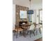 Cozy dining room featuring a wood table, mid-century modern chairs, stone fireplace, and pendant lighting, creating an inviting atmosphere at 5205 Riverview Nw Rd, Atlanta, GA 30327