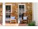 Charming front porch with rocking chairs, stone facade, and brick floor at 5205 Riverview Nw Rd, Atlanta, GA 30327