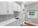 Modern laundry room with custom cabinets, backsplash, and stackable washer and dryer at 5205 Riverview Nw Rd, Atlanta, GA 30327