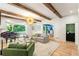 Bright living room with exposed beams, piano, and view to the outside at 5205 Riverview Nw Rd, Atlanta, GA 30327
