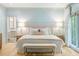 Bright main bedroom featuring a king bed, bench, and large windows for ample natural light and views at 5205 Riverview Nw Rd, Atlanta, GA 30327