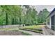 Lush backyard featuring stone pathways, a storage shed, and a wooded border for privacy at 5429 Martins Crossing Rd, Stone Mountain, GA 30088
