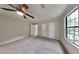 Spacious primary bedroom featuring plush carpeting, ample closet space, and a ceiling fan at 5429 Martins Crossing Rd, Stone Mountain, GA 30088