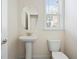 Clean powder room with pedestal sink, toilet, and window for natural light at 6294 Century Park Se Pl, Mableton, GA 30126