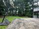 Backyard featuring a basketball court, shed, and mature trees providing ample shade at 6542 Cherry Tree Ln, Atlanta, GA 30328