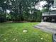 Expansive backyard featuring a patio, a storage shed, and surrounded by mature trees at 6542 Cherry Tree Ln, Atlanta, GA 30328