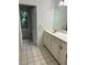 Well-lit bathroom with tiled floor, a large mirror, and a white vanity at 6542 Cherry Tree Ln, Atlanta, GA 30328