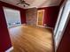 Bedroom featuring hardwood floors, brick accent wall and ceiling fan at 6542 Cherry Tree Ln, Atlanta, GA 30328