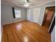 This bedroom offers hardwood floors, a window, a ceiling fan, and a double-door closet at 6542 Cherry Tree Ln, Atlanta, GA 30328