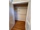 Bedroom walk-in closet with white organizers and wood floor at 6542 Cherry Tree Ln, Atlanta, GA 30328