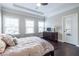 Bedroom with tray ceilings, hardwood floors, three windows, and a comfortable bed at 2048 Rockledge Ne Rd, Atlanta, GA 30324