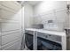 Modern laundry room with front load washer, dryer, and overhead shelving at 2048 Rockledge Ne Rd, Atlanta, GA 30324
