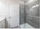Modern shower with frameless glass enclosure and gray wood-look tile, complemented by a white door at 2048 Rockledge Ne Rd, Atlanta, GA 30324