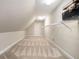 Carpeted attic space with built-in shelving, offering versatile storage or potential for customization at 2050 Woodberry Run Dr, Snellville, GA 30078