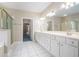 Bright bathroom features a double vanity, white cabinetry, tile flooring, and a tub at 2050 Woodberry Run Dr, Snellville, GA 30078