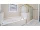 This spa-like bathroom offers a jetted tub and separate shower with sleek tile flooring at 2050 Woodberry Run Dr, Snellville, GA 30078