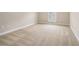 A spacious, carpeted bedroom featuring neutral walls and a window with blinds, providing a blank canvas at 2050 Woodberry Run Dr, Snellville, GA 30078