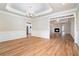 Elegant dining area with hardwood floors, a tray ceiling with chandelier, and views into the kitchen and living area at 2050 Woodberry Run Dr, Snellville, GA 30078