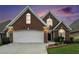 Beautiful brick home with a well-manicured lawn and a two-car garage, offering classic curb appeal at sunset at 2050 Woodberry Run Dr, Snellville, GA 30078